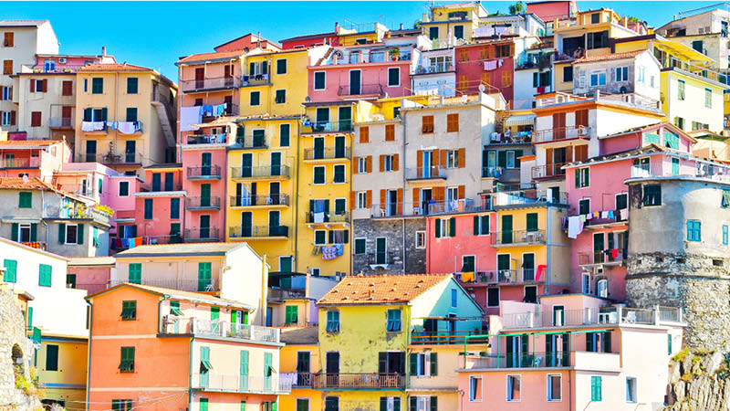 Pastellfärgade hus utmed klippväggen i Cinque Terre, Italien.